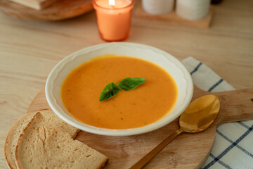 Plate of hot pumpkin soup and a slice of dark bread on the table. Warm autumn food. Immunity.