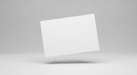 Naklejka premium Blank White Card Floating in Minimalist Gray Studio Setting