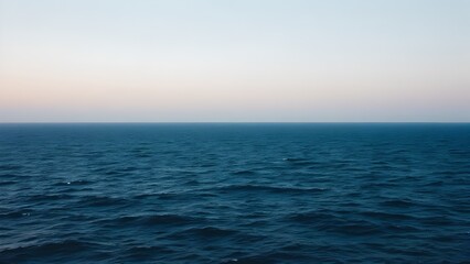 Obraz premium Calm ocean water under a gradient sky at sunrise or sunset