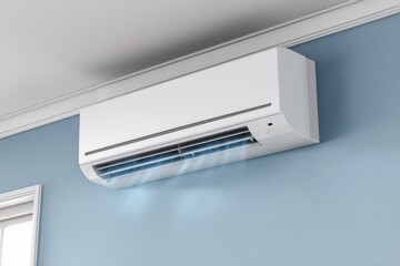 White air conditioner on a light blue wall, blowing cool air into the room, mounted under the white ceiling.