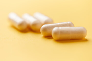 Collagen capsules. Bright paper background. Soft focus. Close up. Copy space.	