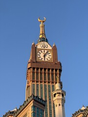 Abraj Al Bait Clock Tower in Mecca during sunset, with Islamic architecture and minarets under a...