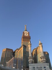 Abraj Al Bait Clock Tower in Mecca during sunset, with Islamic architecture and minarets under a...