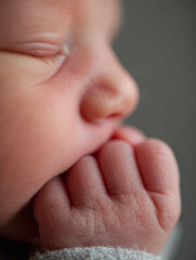 Clenching tiny fist beside face captures a moment of innocence and curiosity in early childhood development