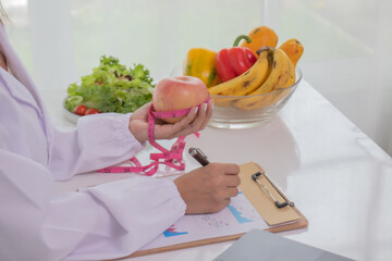 A female lab technician examines broccoli for scientific research in microbiology, biotechnology,...