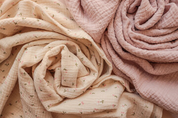 Rolled muslin fabrics in beige with floral print and dusty pink color. Soft natural texture, ideal...