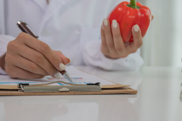 A female lab technician examines broccoli for scientific research in microbiology, biotechnology, and nutrition to advance health.