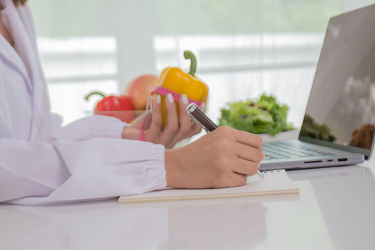 A female lab technician examines broccoli for scientific research in microbiology, biotechnology, and nutrition to advance health.