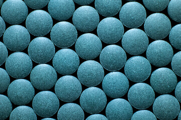 Multiple blue round tablets arranged in geometric pattern. Dietary supplement and pharmaceutical...