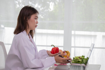 A female lab technician examines broccoli for scientific research in microbiology, biotechnology, and nutrition to advance health.