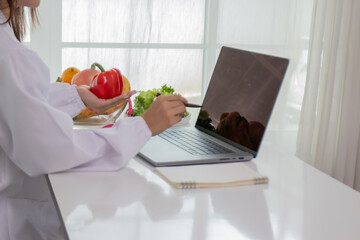 A female lab technician examines broccoli for scientific research in microbiology, biotechnology, and nutrition to advance health.