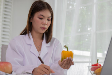 A female lab technician examines broccoli for scientific research in microbiology, biotechnology, and nutrition to advance health.