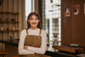 Smiling barista posing with crossed arms in coffee shop