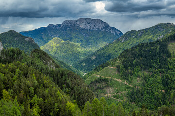Lush green mountain valley under dramatic clouds
