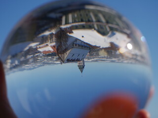 Person is holding a glass ball that has a distorted view of a city