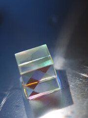 Small cube of glass with a rainbow pattern on it