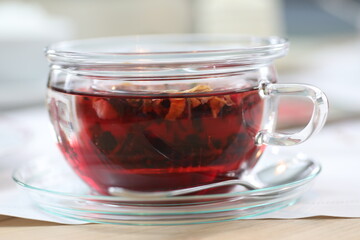 Cup of tea with a spoon in it sits on a saucer