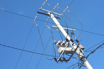 Power lines against bright blue sky background