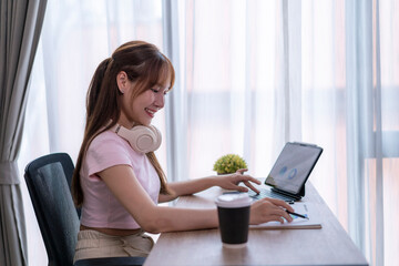 Young woman working on tablet at home office