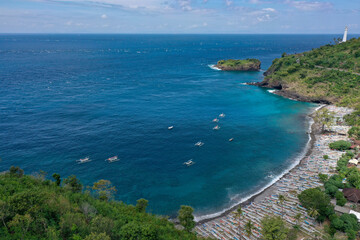 Drone Panorama of Balinese Fishing Bay with White Boats, Forested Hills, and Distant Lighthouse
