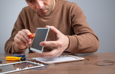 Caucasian man repairing broken tablet. Tablet repair