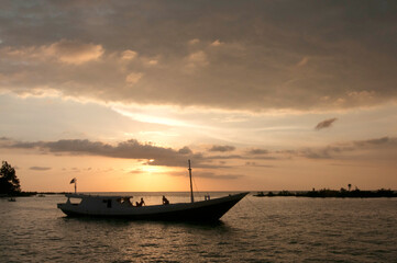 Obraz premium Stunning sunset cruise with friends on a peaceful ocean adventure