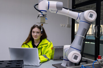Young engineer interacts with robotic arm at a technology lab during a project demonstration in an...