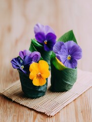 Edible pansy flowers wrapped in banana leaves on rustic table