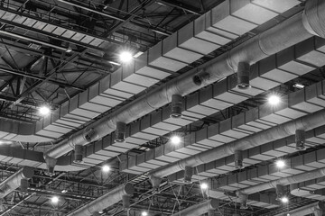 HVAC Duct Cleaning, Ventilation pipes in silver insulation material hanging from the ceiling inside new building.