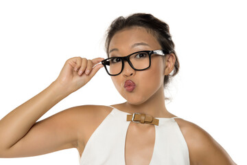 Funny Kazakh woman with glasses making a kissy face, studio shot on white background, humorous...