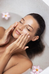 Young Woman Touching Her Face While Relaxing In Skincare Bath Ritual
