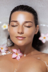 Caucasian Woman In Spa Bath Surrounded By Flowers For Skincare Concept