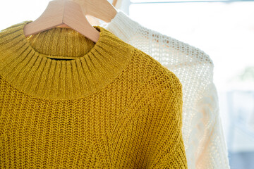 Warm autumn clothes knitted in the closet. Home organization.