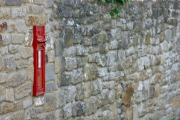Red letter box situation in a stone wall