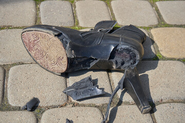 torn old shoes, pieces of torn women's shoes lie on the pavement