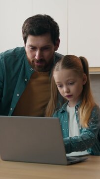 Happy family at home kitchen father busy with cooking daughter child girl asking dad help with online homework studying daddy helping teaching laptop computer e-learning childcare distant education