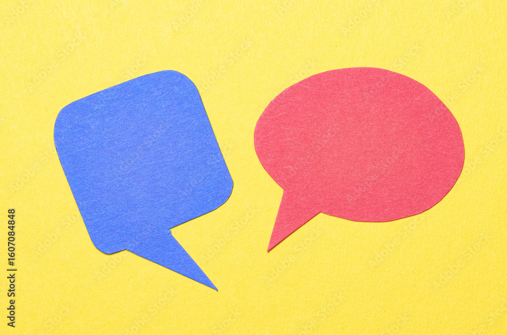 Poster Red blue blank cut out paper speech bubbles with copy space for text on yellow background, flat lay top view conceptual conversation backdrop