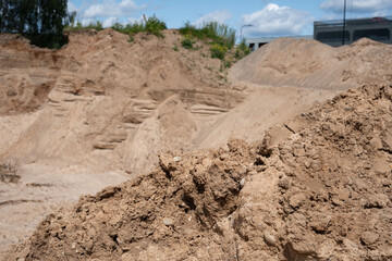 expansive sand dunes under vibrant blue skies in a rugged industrial setting with overlapping...