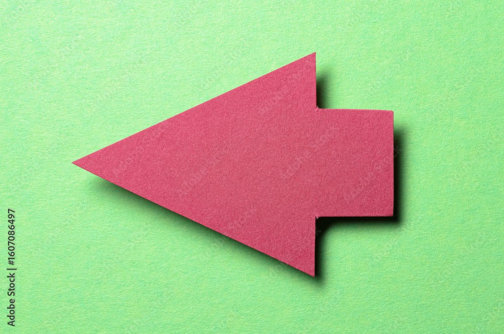 Fototapete red cut out blank paper cardboard arrow direction sign with copy space for text on green background,