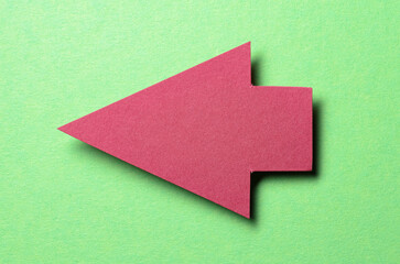 Red cut out blank paper cardboard arrow direction sign with copy space for text on green...