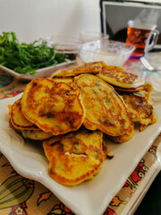 Homemade Vegetable Pancakes on a White Plate with Fresh Herbs and Tea