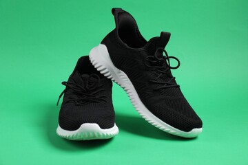 Pair of black sneakers on green background