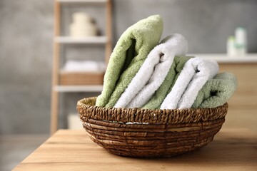 Fresh terry towels on wooden table in bathroom, closeup