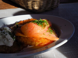 Elegant smoked salmon presentation with cream garnish in dramatic lighting on dark plate