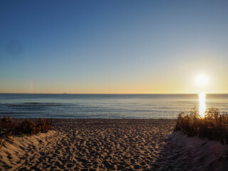 Dramatic sunrise over Baltic Sea with golden sun reflection on ocean horizon