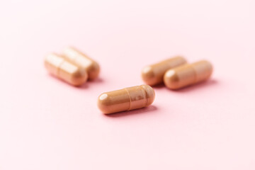 Ginseng capsules on bright background. Soft focus. Close up. Copy space	