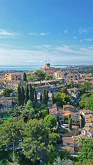 Fototapeta premium Scenic aerial view of a picturesque coastal town with lush greenery, historic architecture, and serene blue waters, capturing the essence of Mediterranean charm and tranquility