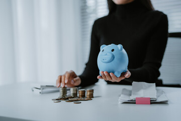 Positive attitude young Asian freelance businesswoman saving money for future, putting coins into...