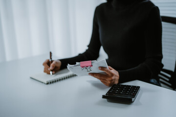 Positive attitude young Asian freelance businesswoman saving money for future, putting coins into...