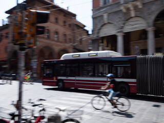 traffic in the city of Bologna with bus moving and cyclist moving riding a bike on the road,...